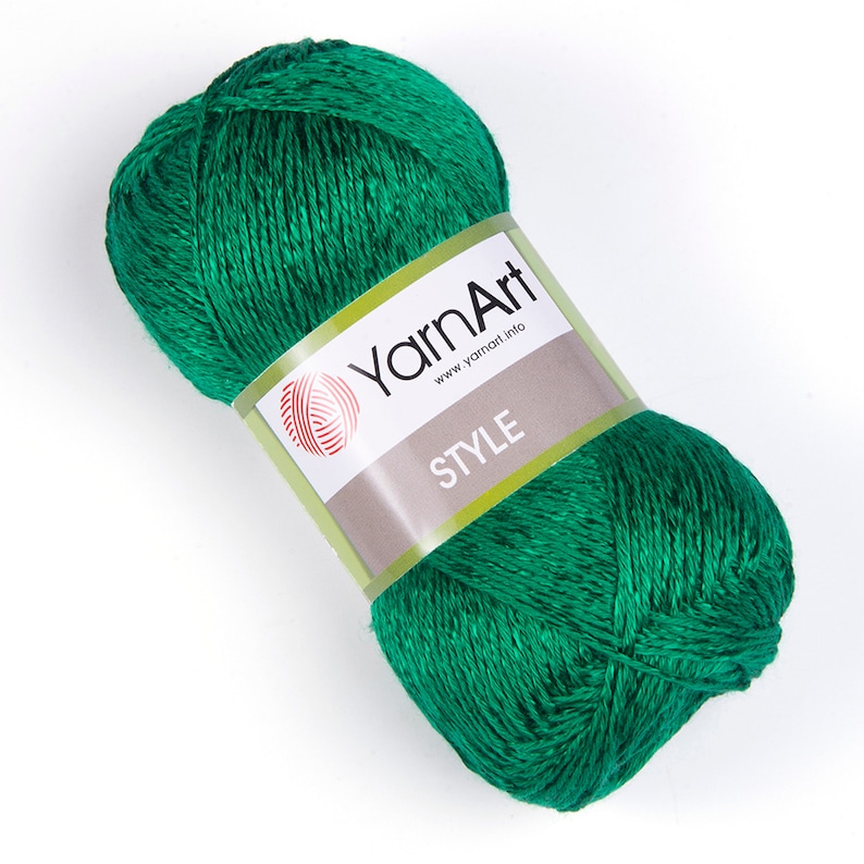Pode incluir: Uma bola de fio verde com um r&oacute;tulo que diz "YarnArt www.yarnart.info STYLE".