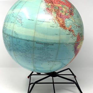 May include: A vintage blue and red globe with a black metal stand. The globe is labeled "Replogle World Globe" and includes a key for understanding the map.