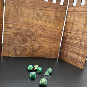 May include: A wooden castle-shaped game board with a set of green and gold dice. The dice are scattered on a black surface in front of the board.