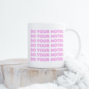 Può includere: Una tazza in ceramica bianca con il testo "DO YOUR NOTES." ripetuto in lettere rosa.