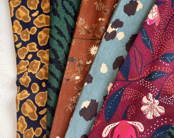 May include: A collection of patterned fabric swatches in various designs and colors. The fabrics include animal prints, floral patterns, and abstract designs in shades of navy, green, brown, and burgundy. The swatches are folded and arranged side by side.