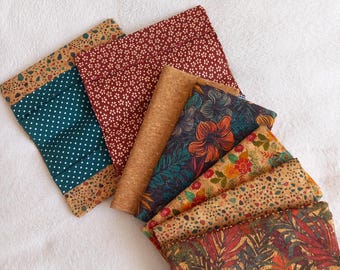 May include: A set of seven fabric pouches with cork backing. The pouches feature various patterns, including floral, geometric, and abstract designs. The pouches are in shades of brown, red, green, and blue.