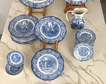 Op de afbeelding: Een set blauw-witte keramische serviesgoed met verschillende historische scènes. De set bevat borden, kommen en een kan.