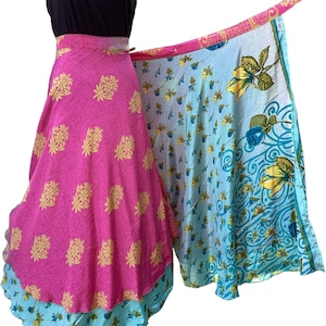 May include: A wrap skirt with a pink floral pattern and a light blue floral pattern. The skirt is layered and has a black top. The skirt is made of a lightweight fabric.