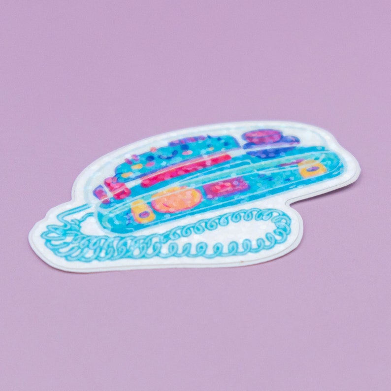 May include: A blue and white phone with a colorful design and a coiled cord. The phone is a vintage style rotary dial phone with a glitter finish.