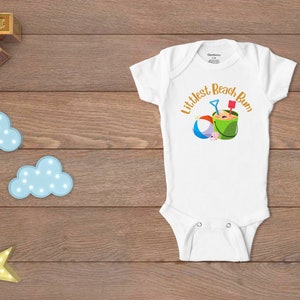 Littlest Beach Bum, featuring a beach ball and bucket of sand.  Shown on a white onesie.