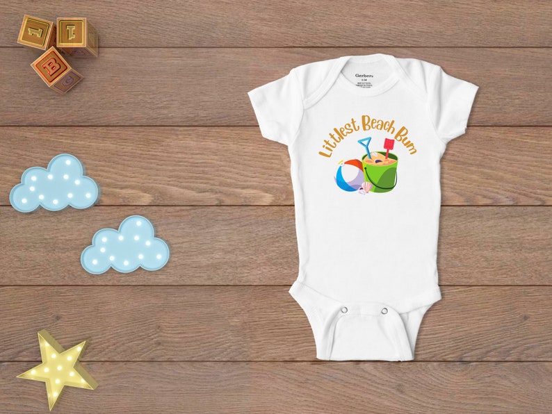 Littlest Beach Bum, featuring a beach ball and bucket of sand.  Shown on a white onesie.