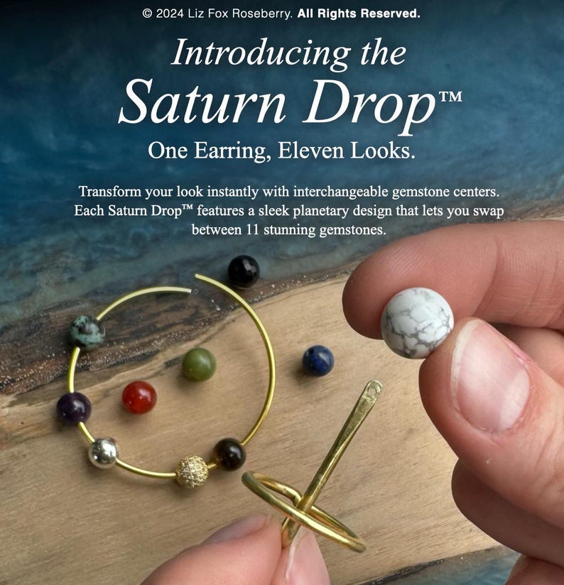 May include: Image of the Saturn Drop&trade; earring with interchangeable gemstone centers. The earring is gold-colored, with a circular design and a variety of colorful gemstones. The text reads "Introducing the Saturn Drop&trade; One Earring, Eleven Looks."