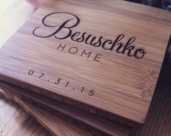 Puede incluir: Conjunto de cuatro posavasos de madera con el texto "Besuschko Home 07.31.15" grabado en el posavasos superior.
