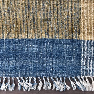 Handwoven area rug featuring geometric color blocks in rich navy blue, warm golden yellow, olive green and natural beige tones. This modern Turkish kilim style rug has a textured flat weave with white fringe edges, perfect for bohemian or Scandinavian interiors. Natural fiber construction creates an eco-friendly floor covering.