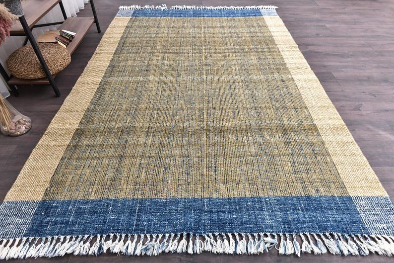 Handwoven area rug featuring geometric color blocks in rich navy blue, warm golden yellow, olive green and natural beige tones. This modern Turkish kilim style rug has a textured flat weave with white fringe edges, perfect for bohemian or Scandinavian interiors. Natural fiber construction creates an eco-friendly floor covering.