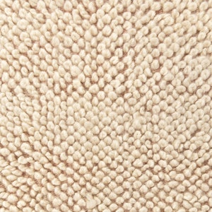 Puede incluir: Primer plano de una tela beige texturizada con un patr&oacute;n circular. La tela tiene una textura suave y peluda.