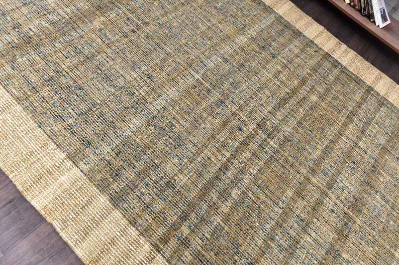 Handwoven area rug featuring geometric color blocks in rich navy blue, warm golden yellow, olive green and natural beige tones. This modern Turkish kilim style rug has a textured flat weave with white fringe edges, perfect for bohemian or Scandinavian interiors. Natural fiber construction creates an eco-friendly floor covering.