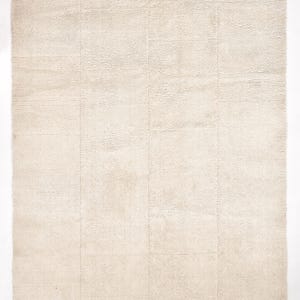 May include: A cream-coloured rug with a subtle woven texture. The rug has a slightly raised border.