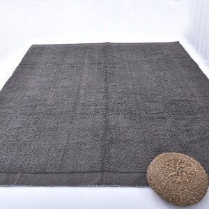 May include: A dark gray area rug with a subtle texture. The rug has a simple, modern design and is perfect for adding a touch of sophistication to any room.