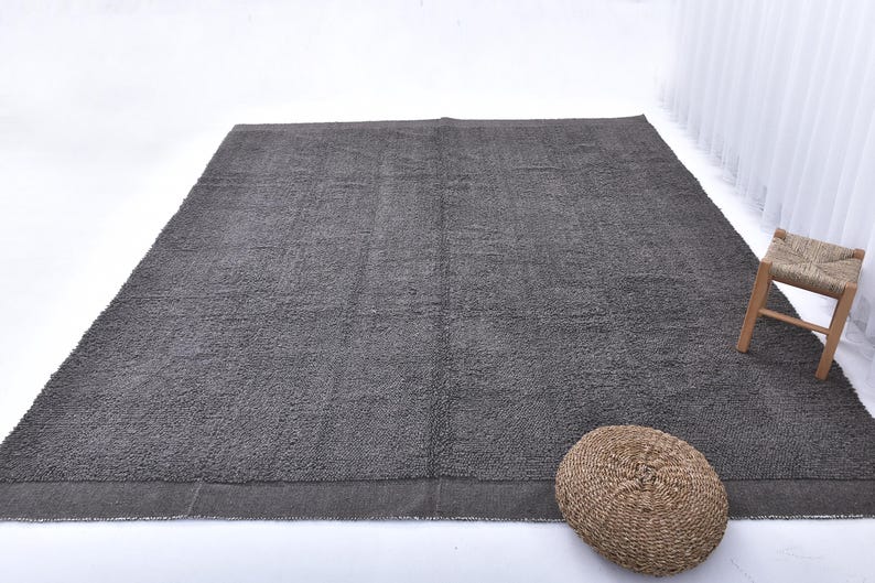 May include: A dark gray area rug with a subtle texture. The rug has a simple, modern design and is perfect for adding a touch of sophistication to any room.