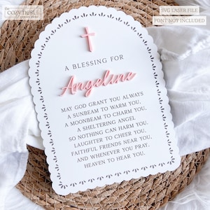 May include: A white, scalloped-edge sign featuring a pink cross and the name "Angeline" in pink script. The sign includes the text "A Blessing For" and a poem. The words "SVG Laser File" and "Font Not Included" are also present.
