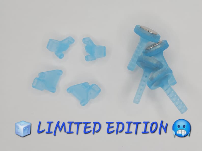 May include: A collection of light blue translucent plastic accessories, including four small shaped pieces and three T-shaped components with metallic circular tops. The text LIMITED EDITION is printed in blue at the bottom with ice cube and face emojis.