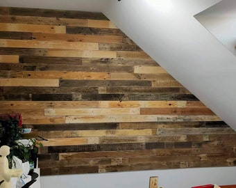 May include: A wall covering made of horizontal wooden planks in varying shades of brown, ranging from light tan to dark espresso. The planks are arranged in a staggered pattern to create a textured surface that follows the slope of the ceiling.