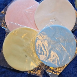 May include: Four round, sheer fabric circles in pink, white, yellow, and blue. The circles are packaged in clear plastic.