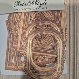May include: A set of paper journal materials featuring die-cut oval and rectangular frames with brown wood-grain patterns. The packaging includes the text Vintage Style Journal Materials, Retro Style, and Make Creative Paper Craft.