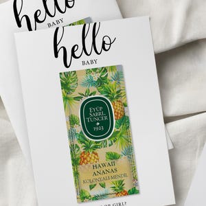 May include: White cards with the text "hello BABY" in black script. One card features a tropical-themed label with pineapples and the text "HAWAII ANANAS KOLONYALI MENDIL" and "BOY OR GIRL?"