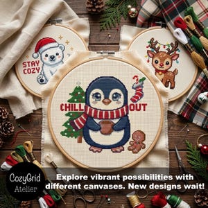 May include: Three circular wooden embroidery hoops containing cross-stitch designs. One features a polar bear with the text STAY COZY, one a reindeer with Christmas lights, and the center one a penguin with the text CHILL OUT.