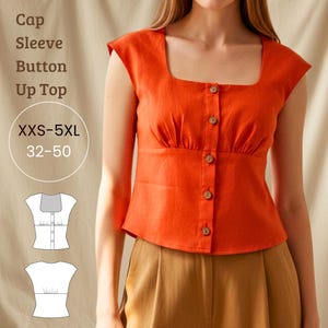 Puede incluir: Una blusa naranja con mangas cortas y botones, con cuello cuadrado y botones de madera. La blusa tiene cintura entallada y se muestra con pantalones marrones. El texto en la imagen dice "Cap Sleeve Button Up Top" y "XXS-5XL 32-50".