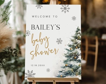 May include: A white welcome sign with gold lettering for a baby shower. The sign says "Welcome to Bailey's Baby Shower 12.16.20XX". The sign features a watercolor illustration of a pine tree with gold ornaments and snowflakes.