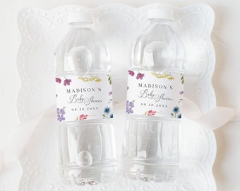 Può includere: Due bottiglie d'acqua in plastica trasparente con etichette che recitano "Baby Shower di Madison" con un design floreale e la data "08.20.2023".