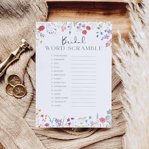 May include: A white card with a floral border and the text "Bridal Word Scramble" printed in black. The card lists 14 words to unscramble, each with a number and a blank line for the answer.