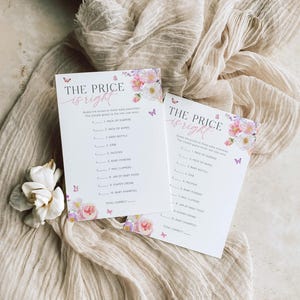 Pu&ograve; includere: Due carte da gioco per baby shower floreali rosa e viola con il testo "The Price is Right" e un elenco di articoli per bambini di cui indovinare il prezzo. Le carte hanno farfalle e motivi floreali.