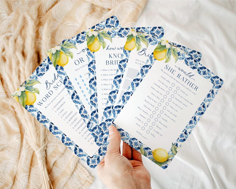 May include: A set of four blue and white patterned bridal shower game cards with lemon illustrations. The games include "Bride Word Scramble", "How Well Do You Know The Bride", "This or That", and "She Would Rather".