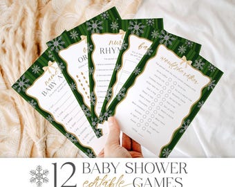 Pode incluir: Um conjunto de cartões de jogos para chá de bebé verdes e brancos com detalhes de flocos de neve e laços. Os cartões apresentam vários títulos e perguntas de jogos, com o texto "12 BABY SHOWER editable GAMES" na parte inferior.