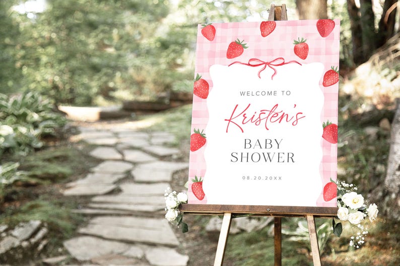 May include: A pink and white gingham baby shower welcome sign with red strawberries and the text "Welcome to Kristen's Baby Shower 08.20.20XX".