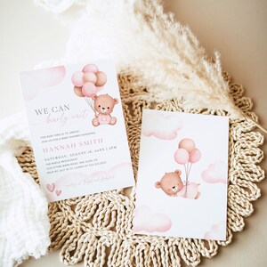 Puede incluir: Una invitaci&oacute;n de baby shower rosa y blanca con un oso de dibujos animados sosteniendo globos. La invitaci&oacute;n dice "We can barely wait" para la beb&eacute; Amelia. La invitaci&oacute;n incluye la fecha, la hora y la ubicaci&oacute;n de la ducha.