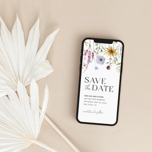 May include: A smartphone displaying a save the date card with a floral design. The text on the card reads "Save the Date" and includes the names "Adaline and Ryder" and the date "Saturday, May 18, 20XX".