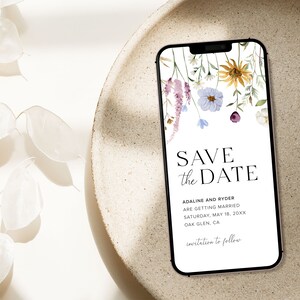 May include: A digital save the date card with a floral design. The text reads "Save the Date" with the names "Adaline and Ryder" and the date "Saturday, May 18, 20XX". The location is "Oak Glen, CA". The text "invitation to follow" is at the bottom of the card.