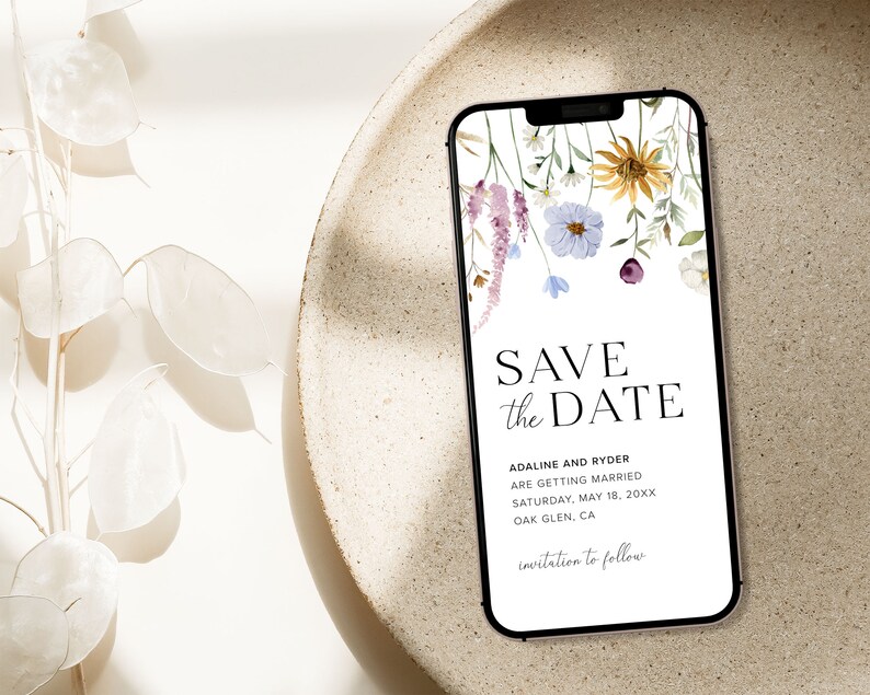 May include: A digital save the date card with a floral design. The text reads "Save the Date" with the names "Adaline and Ryder" and the date "Saturday, May 18, 20XX". The location is "Oak Glen, CA". The text "invitation to follow" is at the bottom of the card.
