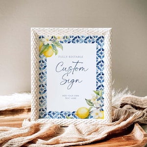 May include: A white frame with a blue and white tiled border surrounds a printable sign that says "Fully Editable Custom Sign Add Your Own Text Here". The sign features a watercolor illustration of lemons and white flowers.