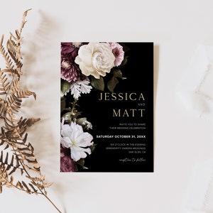 May include: Black wedding invitation with gold lettering. The invitation features a floral design with white and burgundy flowers. The text reads "Jessica and Matt Invite you to share their wedding celebration Saturday October 31, 20XX 6 o'clock in the evening Serendipity Garden Weddings Oak Glen, CA RSVP to follow"