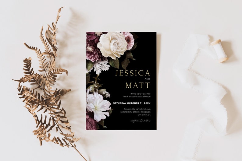 May include: Black wedding invitation with gold lettering. The invitation features a floral design with white and burgundy flowers. The text reads "Jessica and Matt Invite you to share their wedding celebration Saturday October 31, 20XX 6 o'clock in the evening Serendipity Garden Weddings Oak Glen, CA RSVP to follow"
