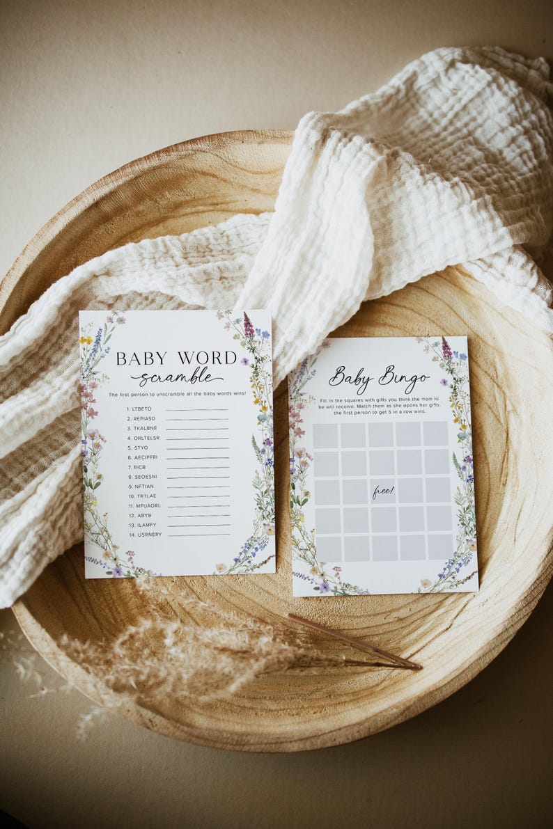 May include: Two printable baby shower game cards with a floral border. The first card is a baby word scramble game with 14 words to unscramble. The second card is a baby bingo game with a free space in the middle.