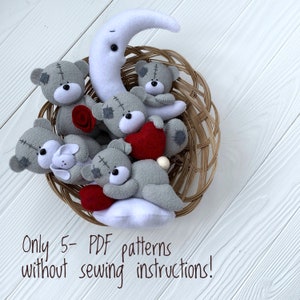 May include: A basket filled with five gray felt teddy bears, each with a different accessory. One bear holds a red heart, another a red rose, and another a white cloud. There is also a white felt crescent moon. The text "Only 5 - PDF patterns without sewing instructions!" is printed below the basket.