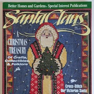 May include: A vintage 1992 "Santa Claus" magazine cover. The cover features a cross-stitch design of Santa Claus holding a Christmas tree. The magazine is a "Christmas Treasury" of crafts, collectibles, and folklore. The cover has a blue background with white snowflakes.