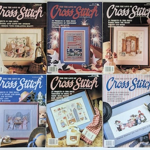Puede incluir: Una colección de seis revistas vintage "For the Love of Cross Stitch". Cada portada presenta diseños de punto de cruz, con títulos como "Floral Designs" y "Patriotic Tributes". Las revistas son de varios colores, con el título en letra cursiva.