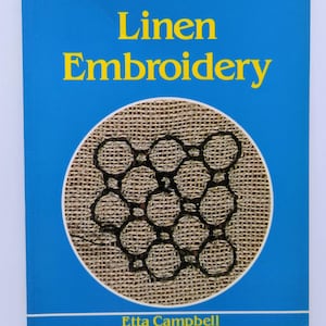 May include: A Batsford Embroidery Paperback book titled "Linen Embroidery" by Etta Campbell. The book cover is blue with yellow text. A circular design in the center features a beige woven fabric with a black embroidered pattern.