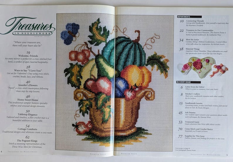Op de afbeelding: Een kruissteekontwerp van een overvloedshoorn vol fruit en groenten, waaronder een watermeloen, pompoenen en druiven. De afbeelding komt uit een tijdschrift getiteld "Treasures in Needlework."