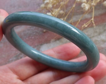 May include: A jade green bangle bracelet with a smooth, polished finish.