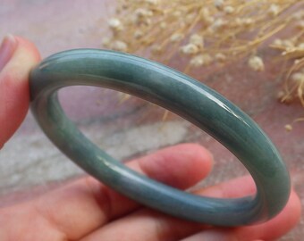 May include: A jade green bangle bracelet with a smooth, polished finish.